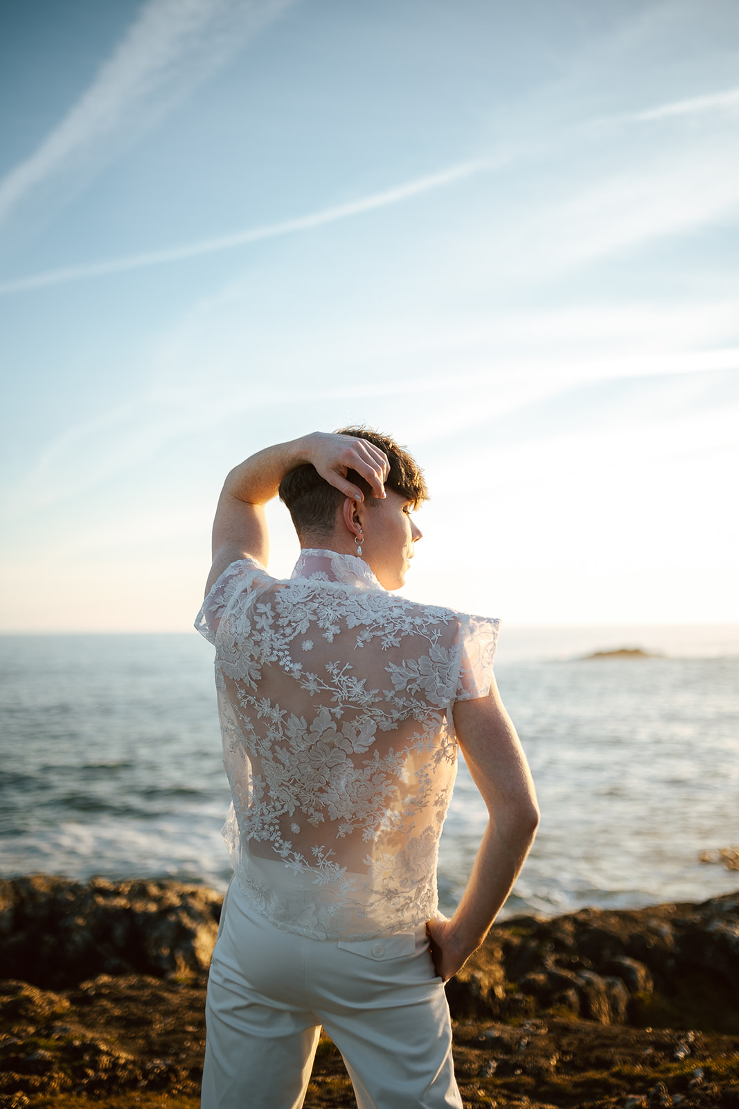 Homme portant un costume de mariage en dentelle sur-mesure en bord de mer.