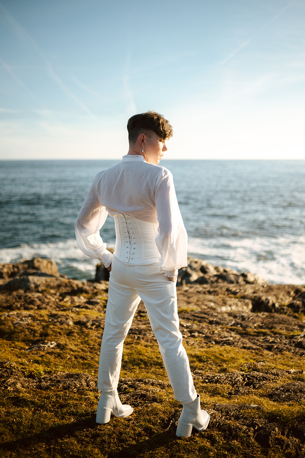 Homme portant un costume de mariage avec corset sur-mesure en bord de mer.